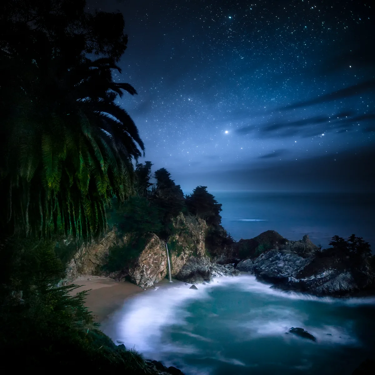 McWay Falls pouring onto the beach in a moonlit cove at Big Sur, California