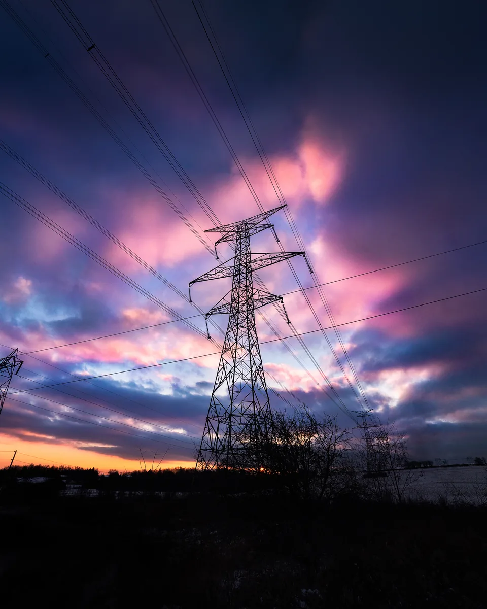 A hydro tower against a streaking pink and blue sunset in Enfield, Ontario