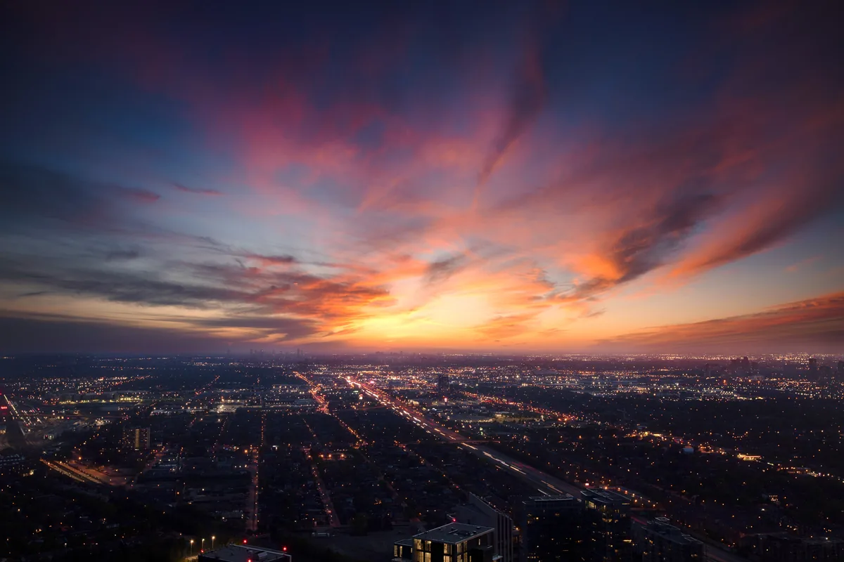 Afterglow, the city grid of Etobicoke, Toronto, glowing under a fiery sunset sky