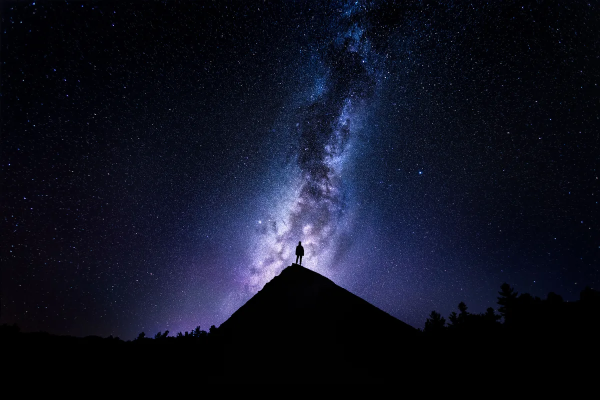 Stillness, a figure on a hilltop beneath the Milky Way near Parry Sound, Ontario